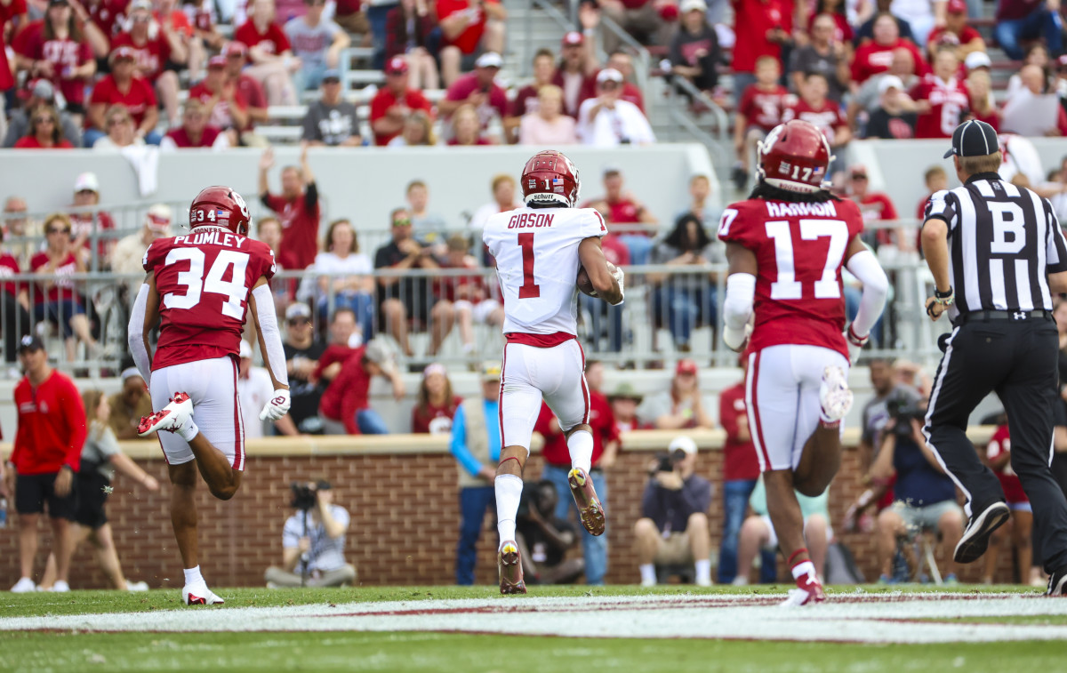 Oklahoma Sooners wide receiver Jayden Gibson scores a touchdown while two of his teammates chase after him in the annual spring game